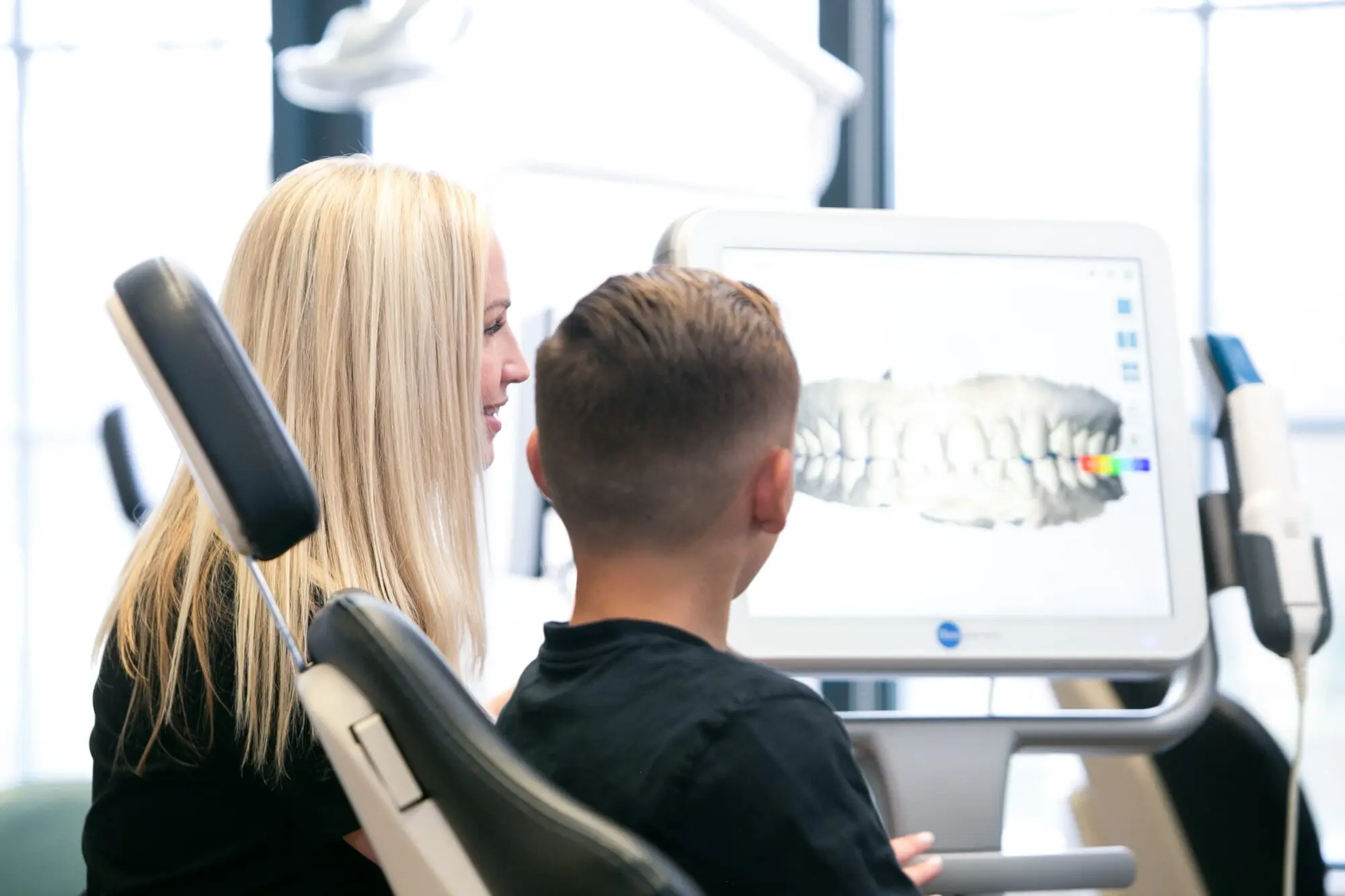 At Koerich Orthodontics in Charlotte, Indian Trail, or Monroe NC, a dental professional and a young patient view a 3D digital model of teeth on a monitor in the dental office.