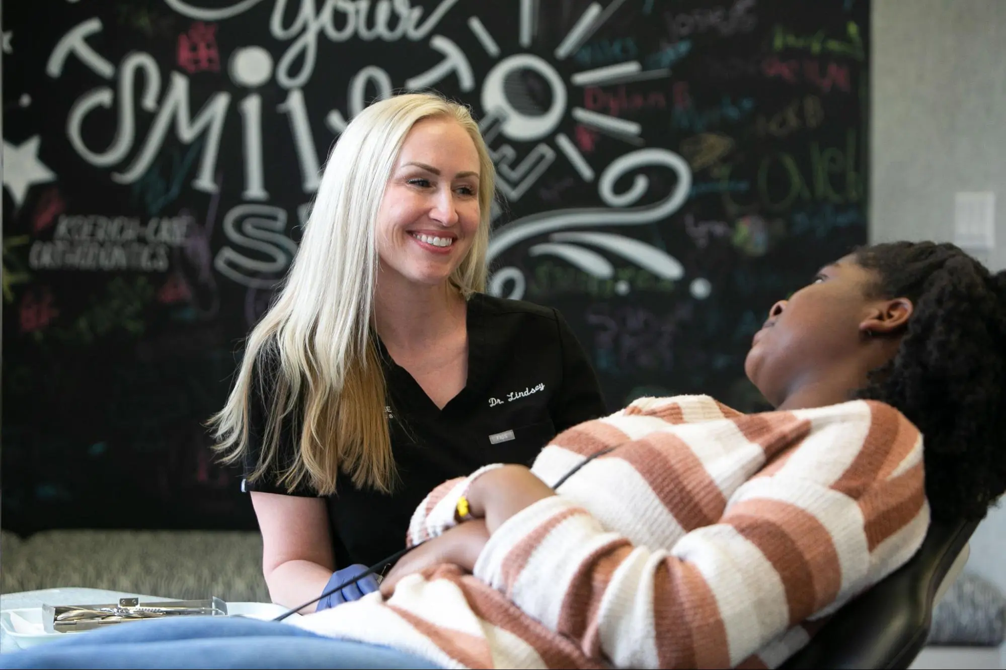 A dentist from Koerich Orthodontics chats with a patient in a dental office at Koerich Orthodontics in Monroe NC