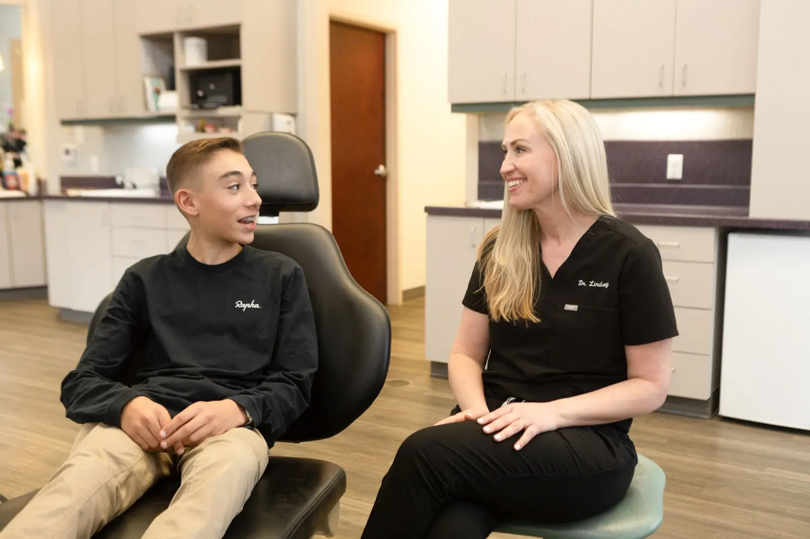 A teenage boy discusses braces with a dental professional at Koerich Orthodontics in Indian Trail, NC.