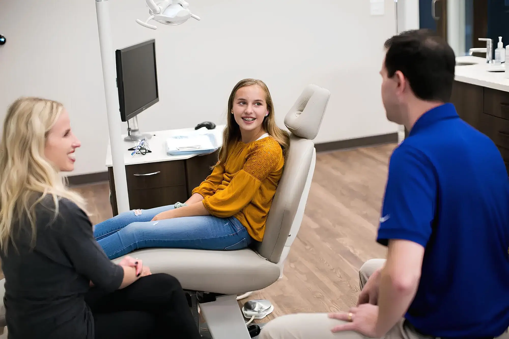 A child woman smile sitting in a dental chair during appointments with top-rated children’s orthodontist in Charlotte, Indian Trail and Monroe, NC.