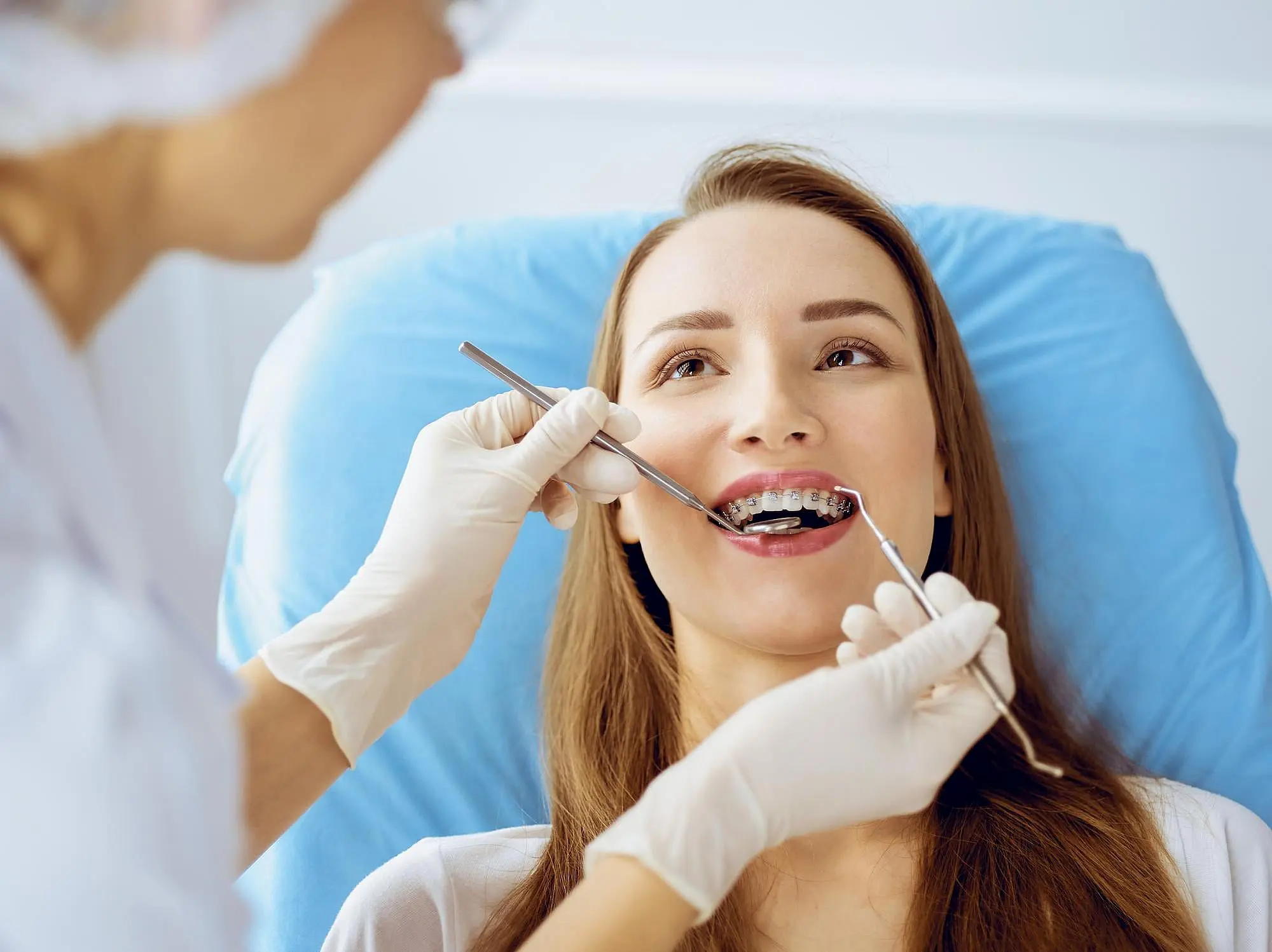 A woman receives a dental checkup with dentist and discussing the benefits of metal braces in Indian Trail, NC.