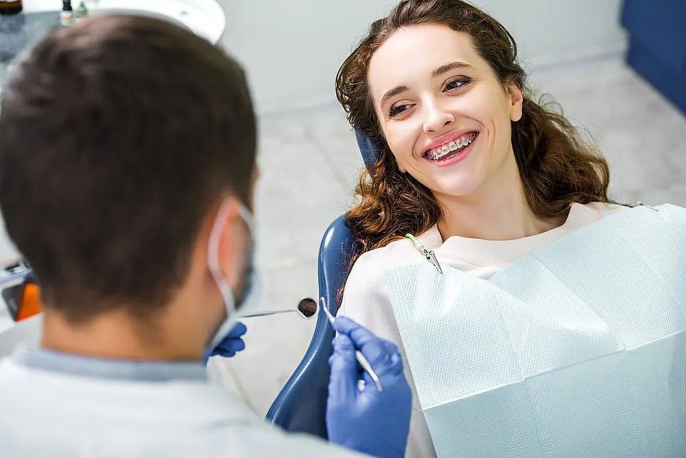 A woman with sparkling braces beams a radiant smile and getting free orthodontic Consultation for Braces from Koerich Orthodontics in Indian Trail, NC.