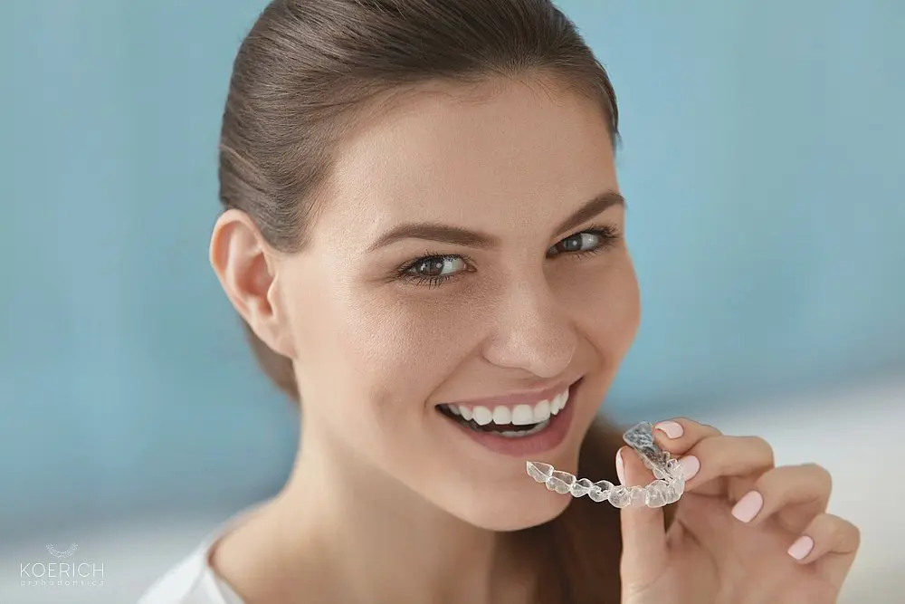 a beautiful woman smiling while using removable invisalign clear aligners after understanding does insurance cover invisalign in charlotte, nc