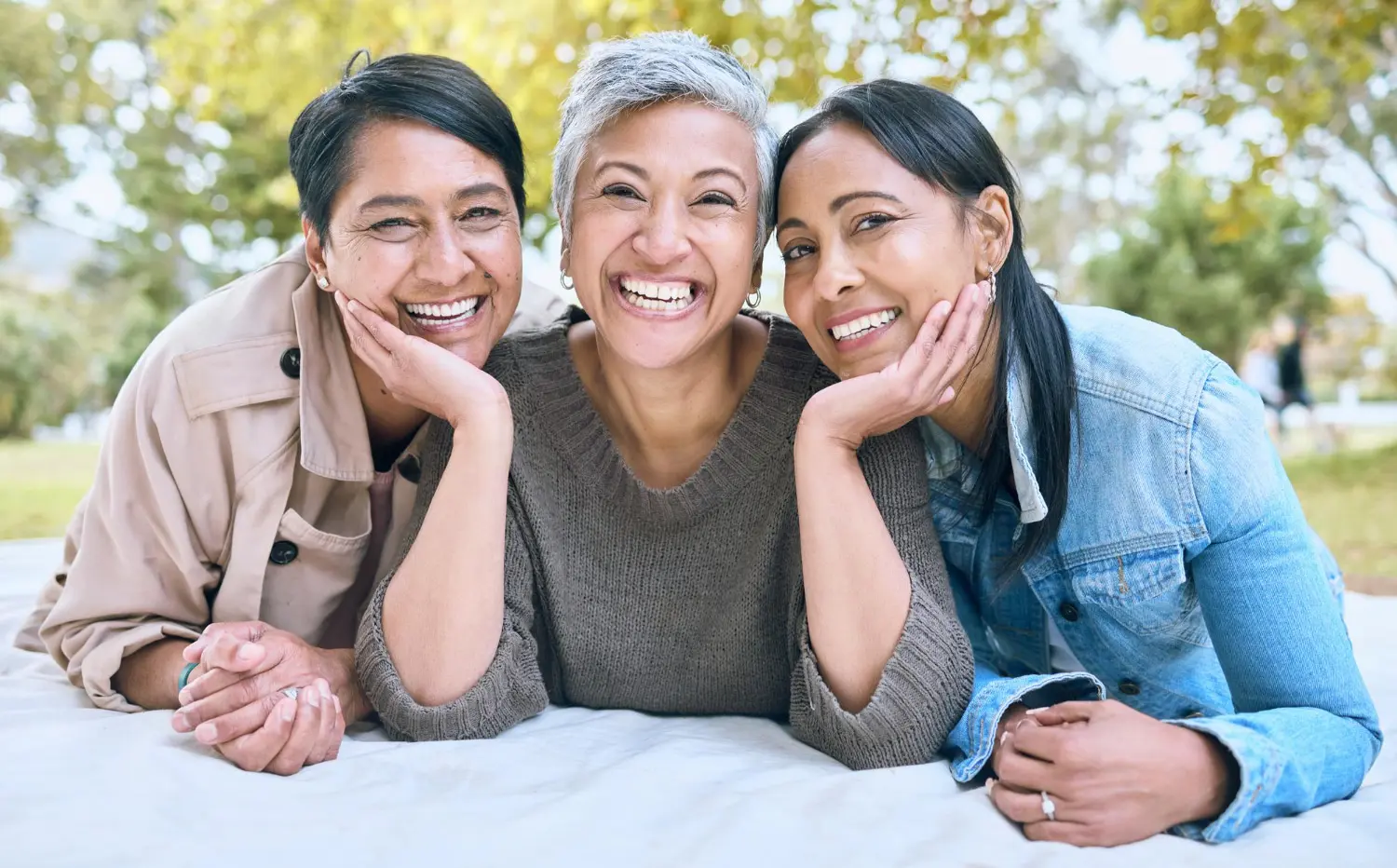 Three adult woman smile and like with benefit adult Orthodontics at Koerich Orthodontics located in Charlotte, Indian Trail and Monroe, NC.