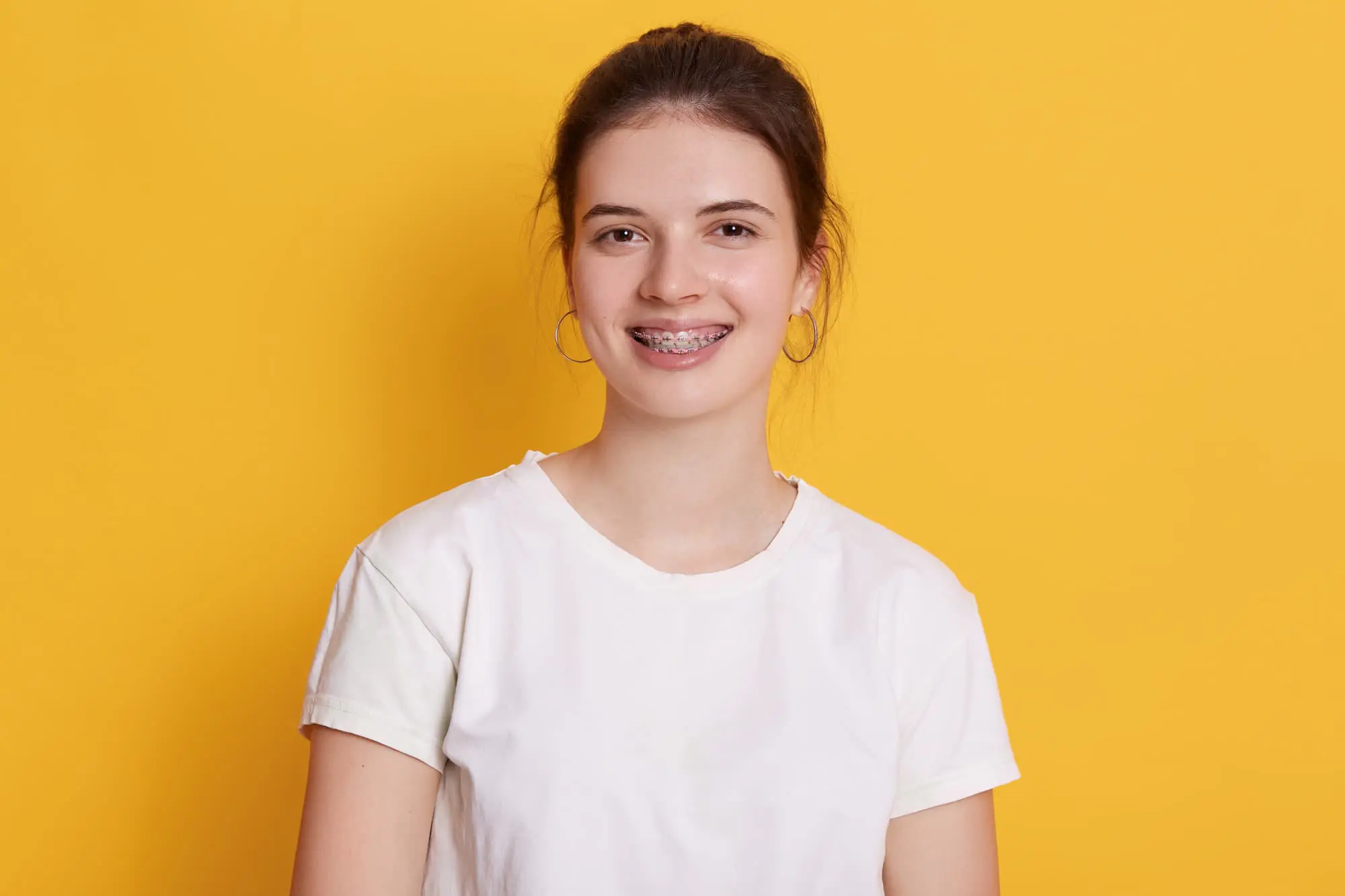 A woman with metal braces smiles at the camera, highlighting trusted orhtodontist in Charlotte, Indian Trail and Monroe, NC.