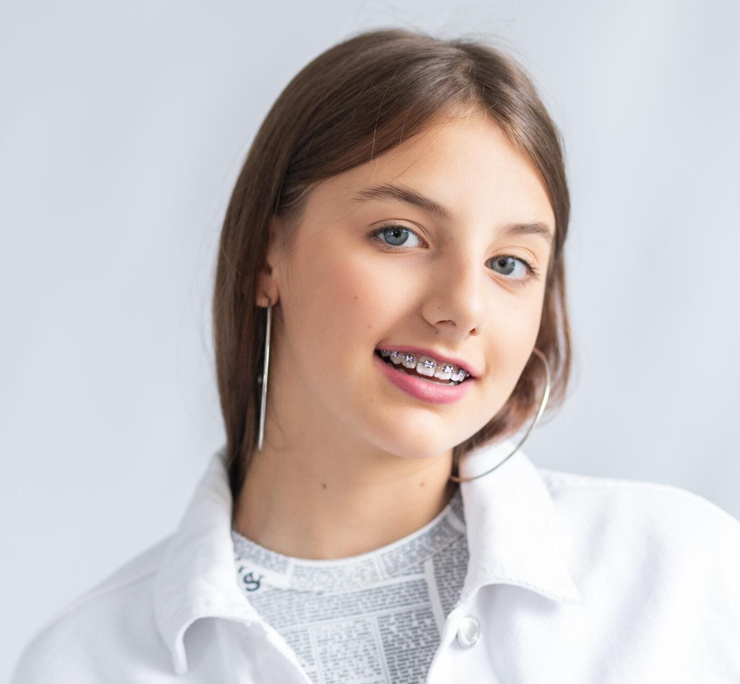 A child woman smiling with metal braces show journey dental treatment by trusted children’s orthodontist in Charlotte, Indian Trail and Monroe, NC.